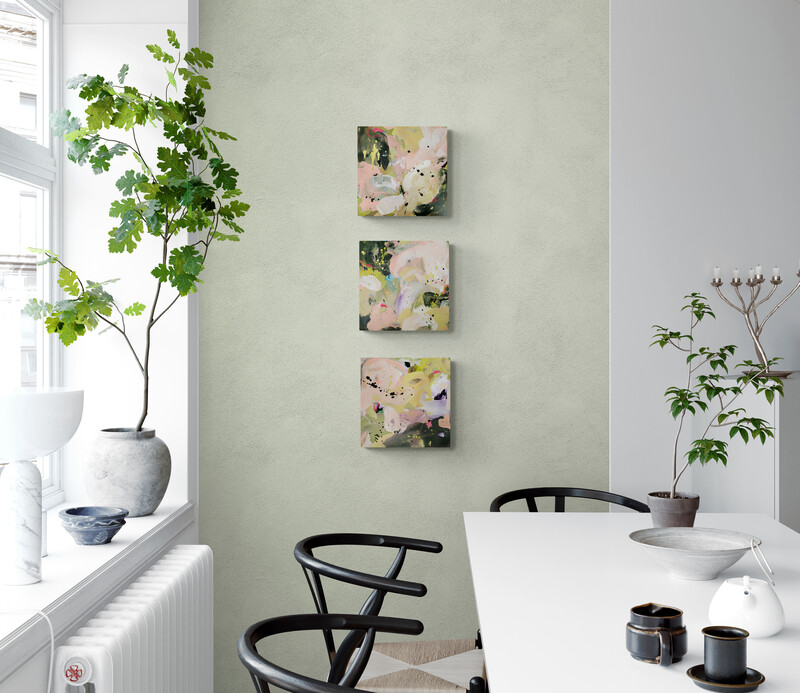 Green dining room with warmer weather outside. Art pieces by Marianne Nielsen are hanging on the wall.