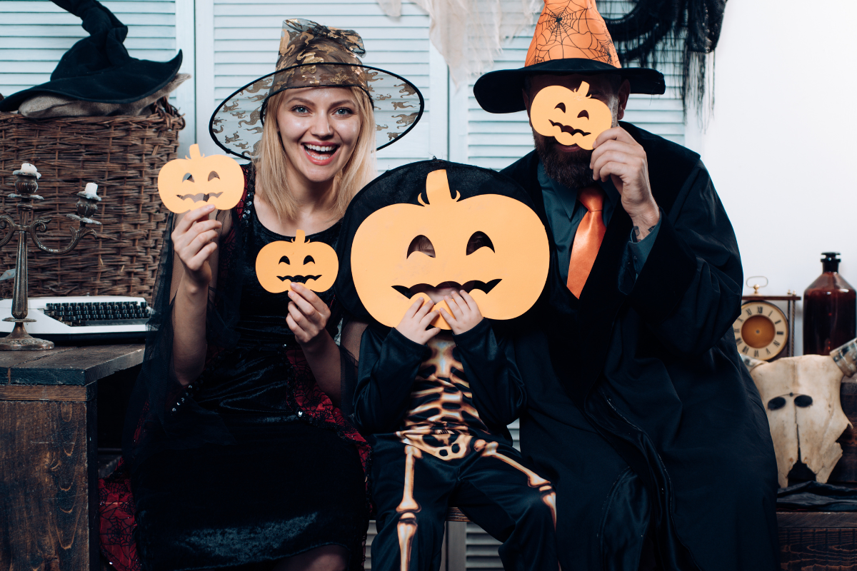 A family dressed in classic Halloween costumes, including a witch and a ghost.