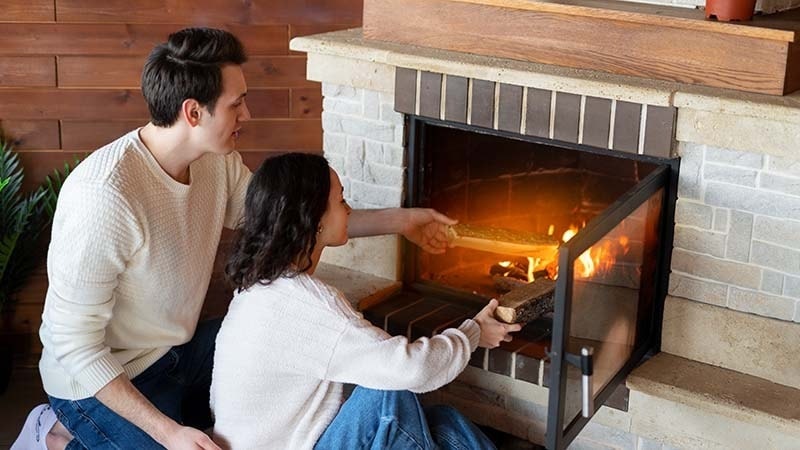 A couple in front of their fireplace