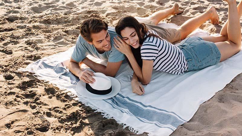 A couple lying on a beach blanket