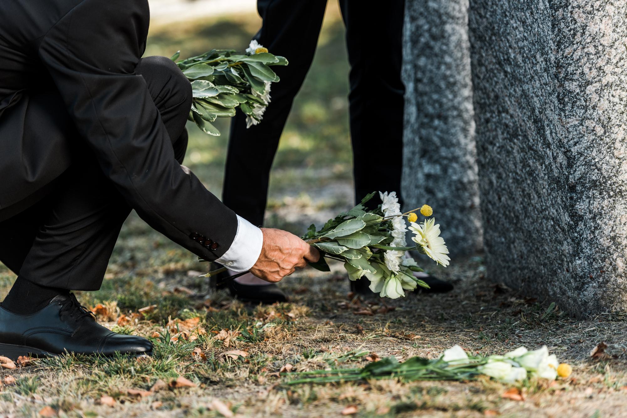 Man laying flowers on a grave - Tampa wrongful death lawyer