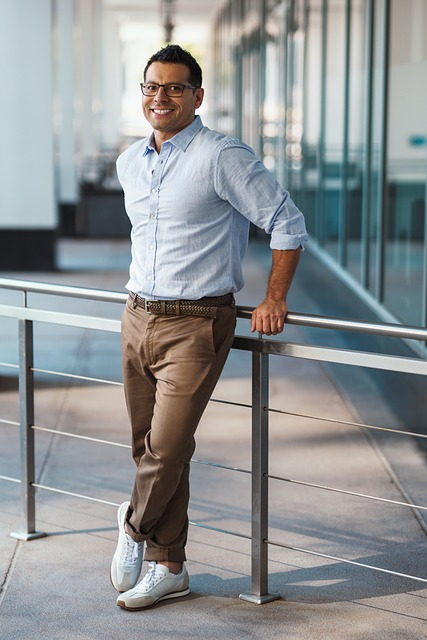 How Minority Temporary Staffing Solutions Can Optimize Your Business Operations 8 businessman dressed in business casual and wearing glasses standing in front of ralilng smling