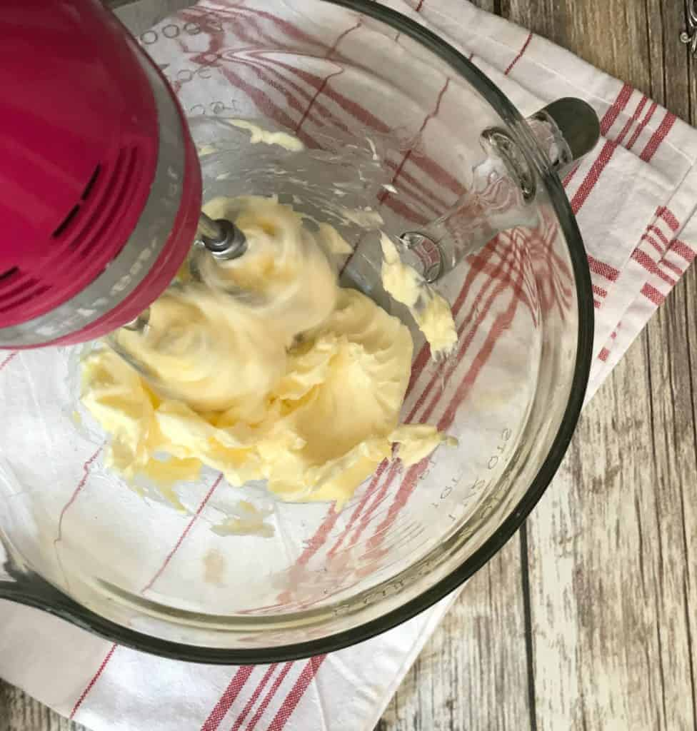 butter and shortening being creamed together in bowl with a hand mixer