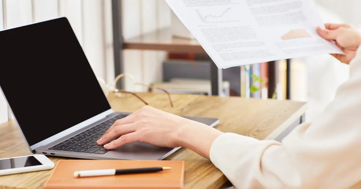 Woman reviewing documents of converting LLC to S Corp to save on taxes and avoid double taxation.