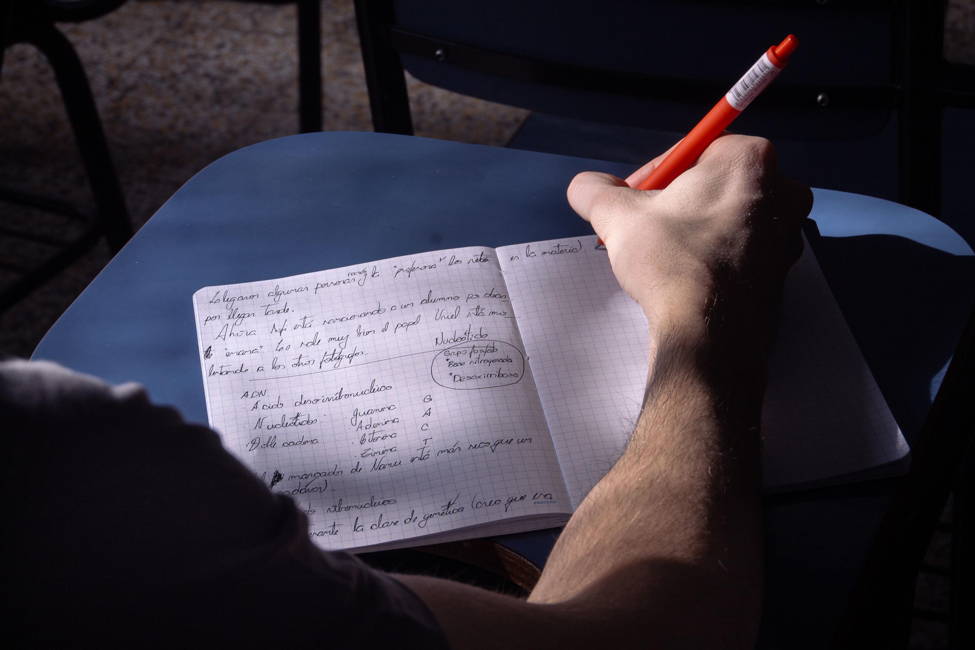 Image credit: jessica olivella via Pexels. Hand holding a red pen drawing diagrams in a notebook. 