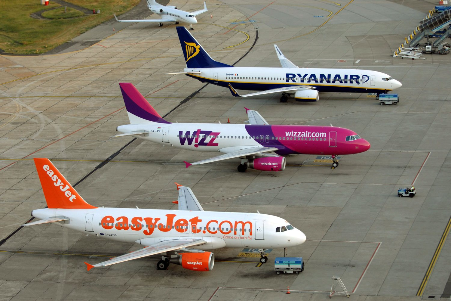 EasyJet, WizzAir and Ryanair narrow-body aircraft stationed at an airport.
