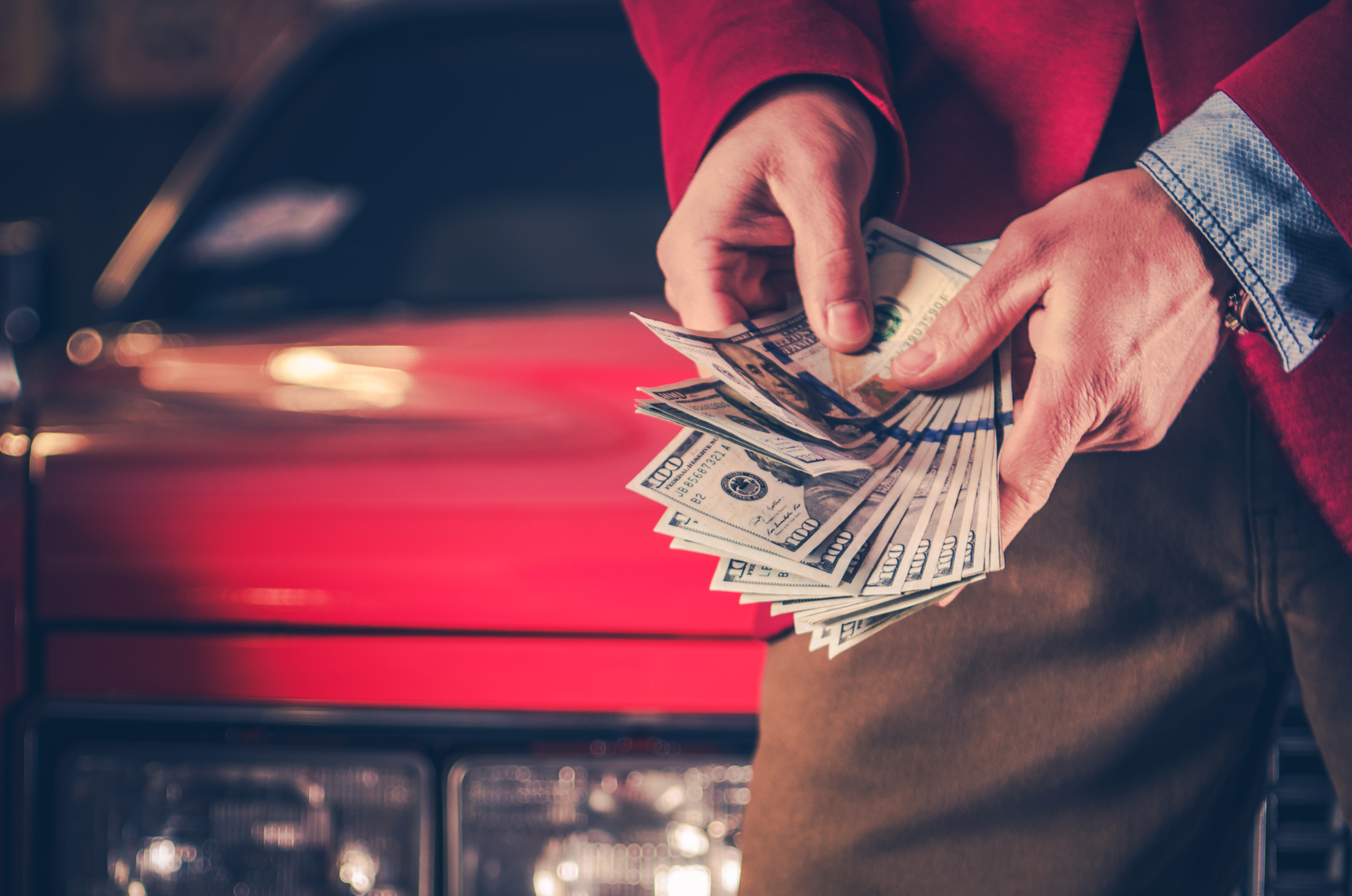 An image of a happy car seller receiving cash for their vehicle, illustrating the what is cash for cars process.