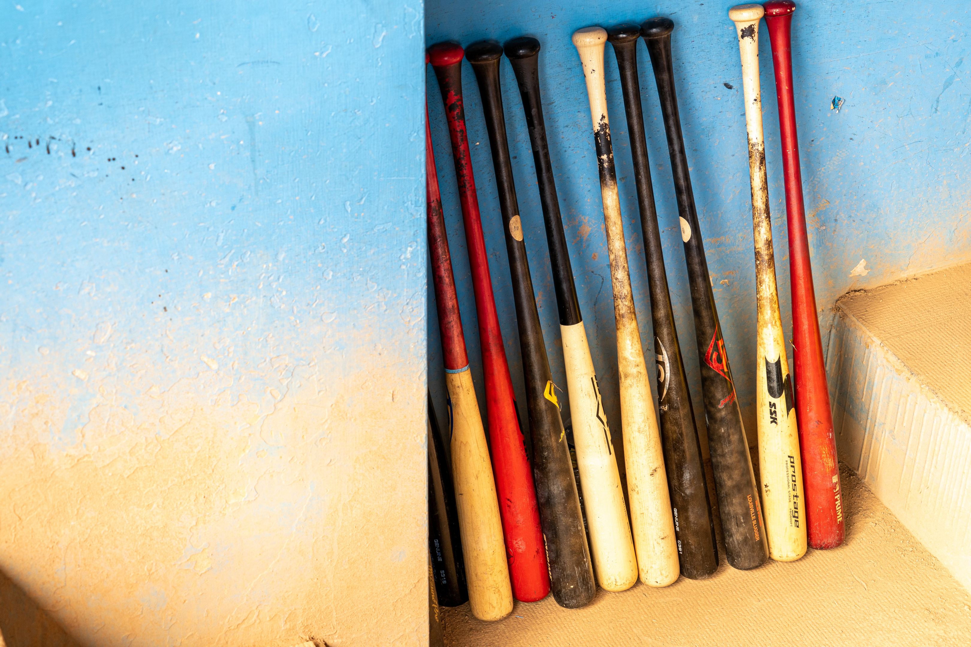 A number of wooden bats in a dugout.