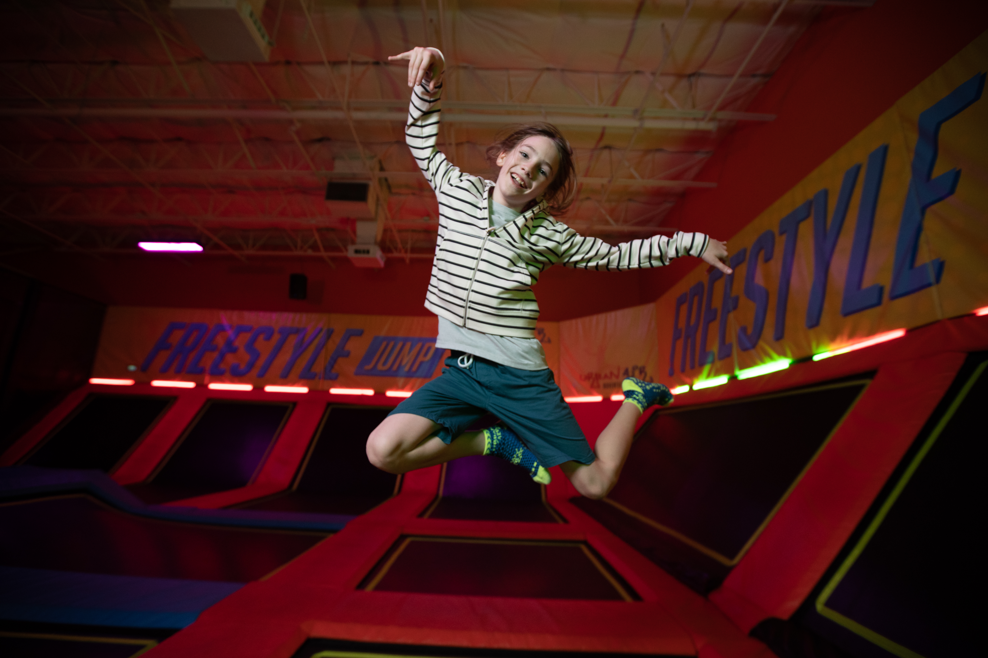 A girl jumps and laughs at Urban Air. All games are more fun when you're jumping on a trampoline. 