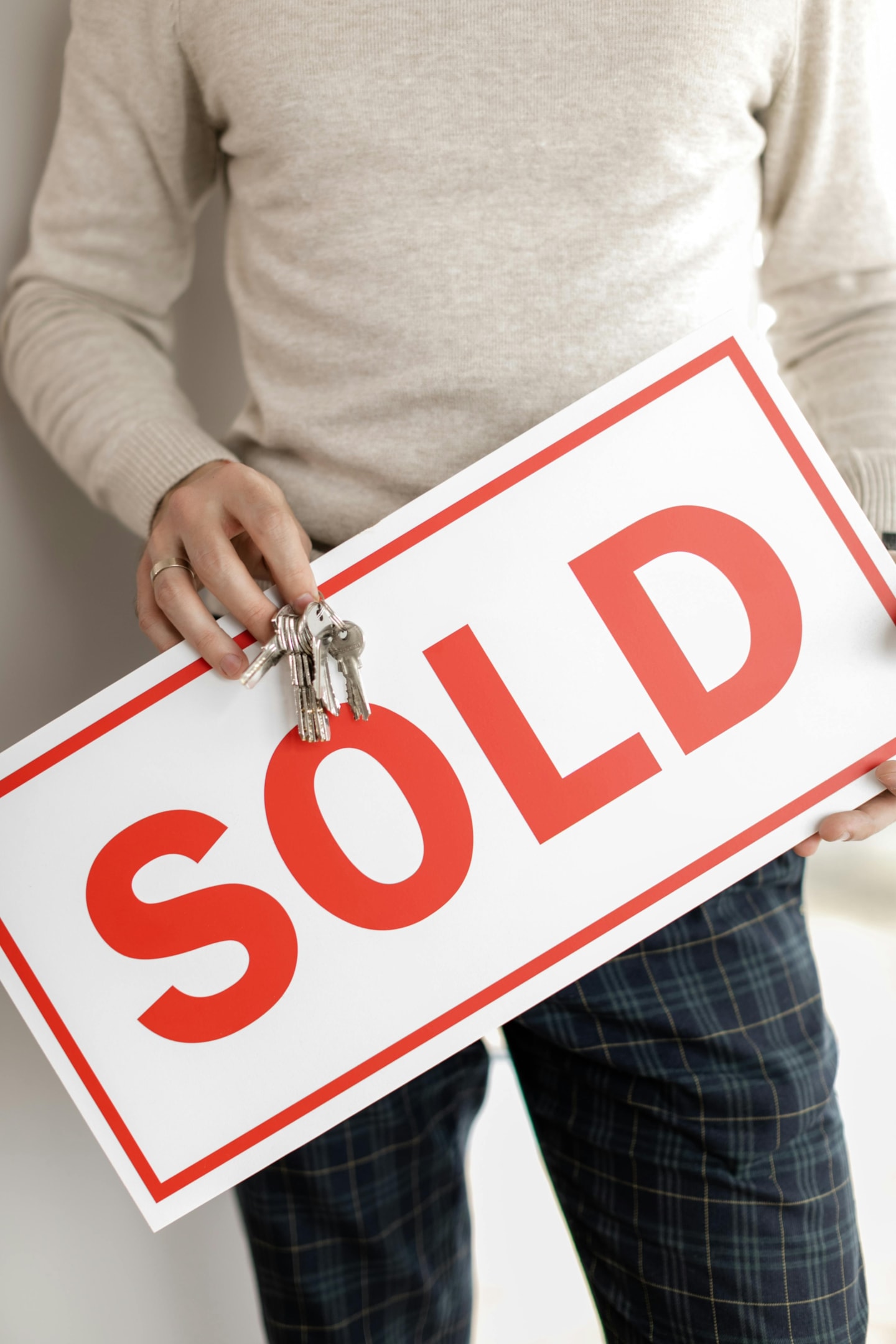 Sold sign being held by property investor. 