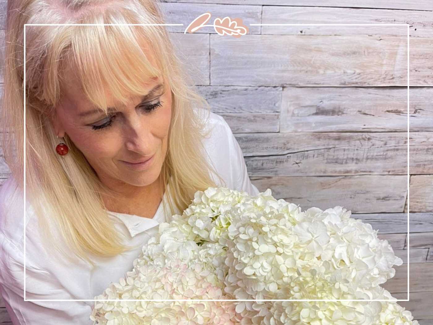 Woman with blonde hair holding a bouquet of white flowers - Fabulous Flowers and Gifts