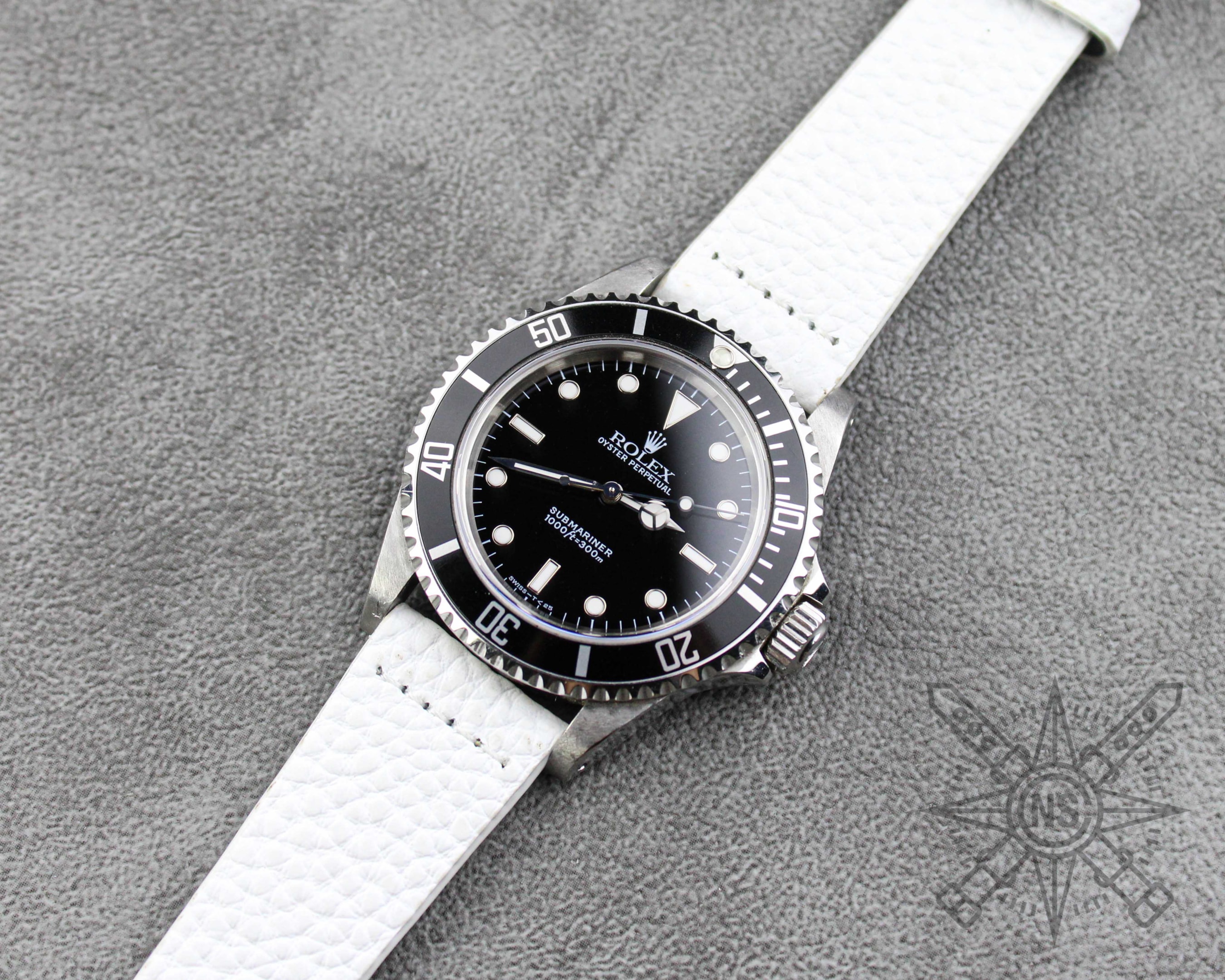 A close-up of a white leather watch strap highlighting its craftsmanship.