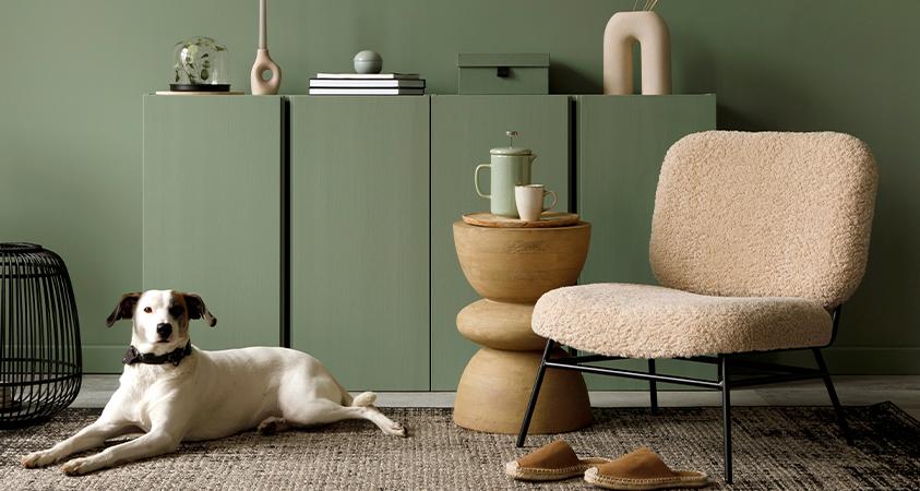 This boucle armchair paired with a wood coffee table stands out in a green living room.