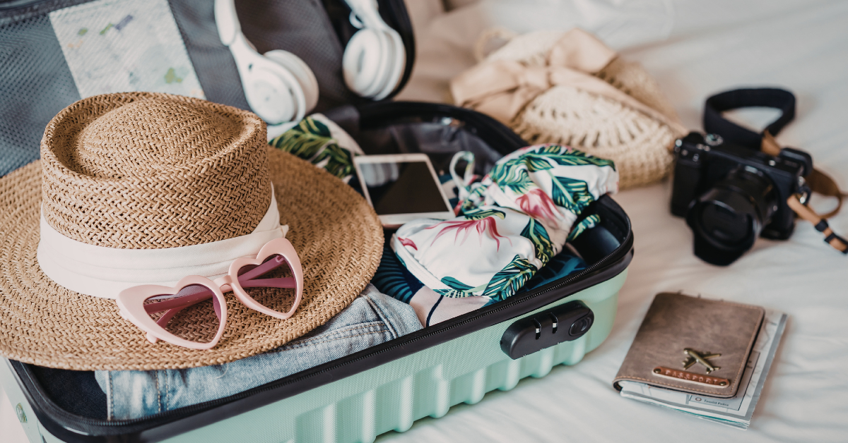 Packed suitcase with summer vacation essentials including sunhat, sunglasses, and swimwear, ready for a Point Pleasant Beach, New Jersey vacation rental getaway