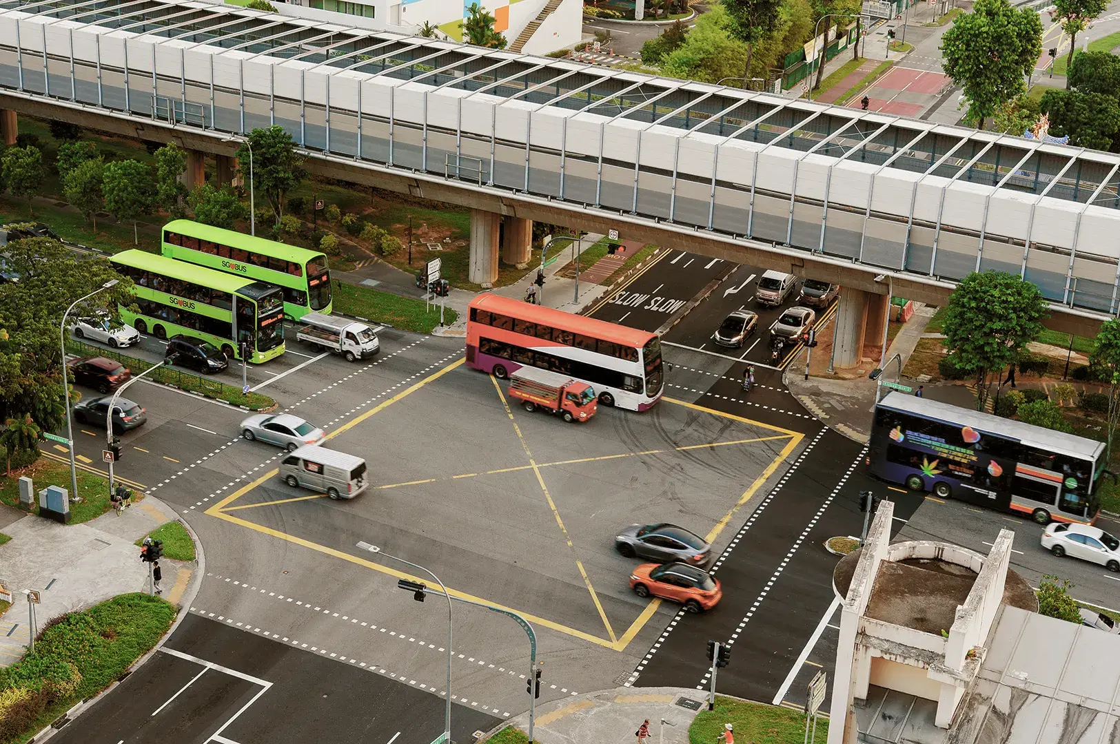 Aerial view of buses and cars at covered pedestrian crossing.