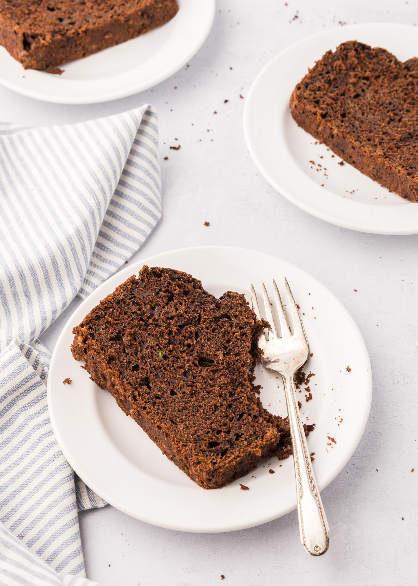slice of chocolate zucchini bread on a plate with a fork