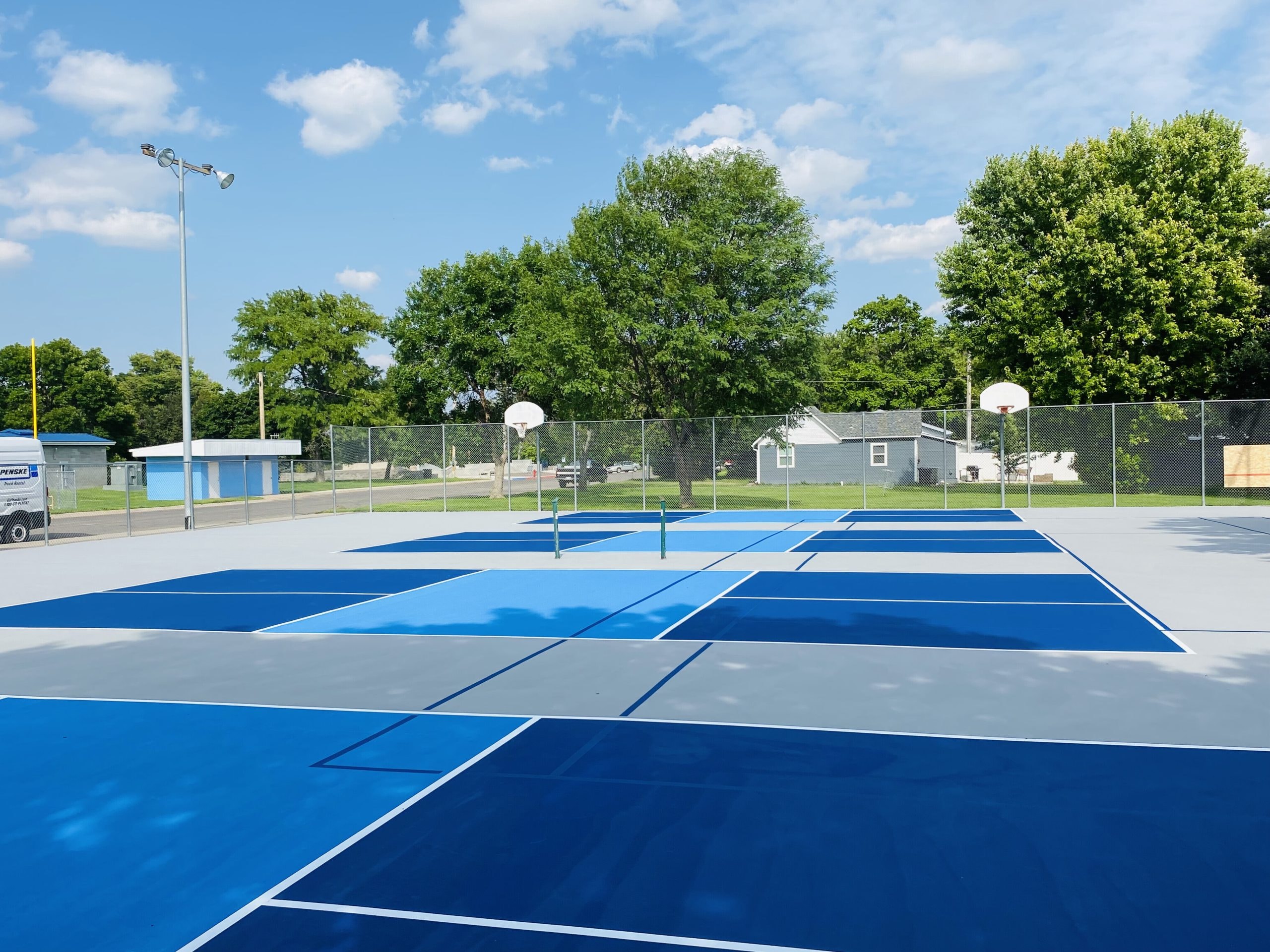 Transformed pickleball courts in Imperial City, NE, featuring a newly resurfaced acrylic surface with four dedicated pickleball courts and ghost lines for tennis.