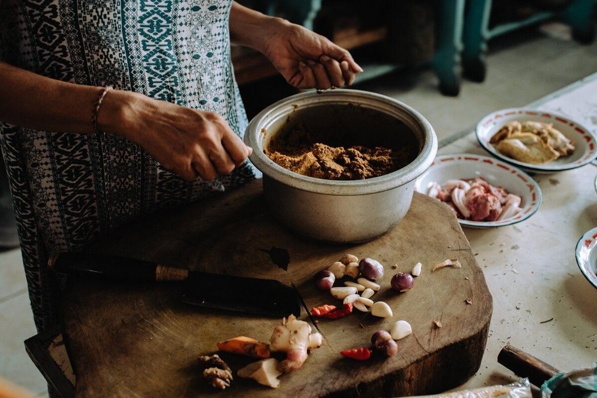 A traditional Balinese meal being prepared, with fresh ingredients and vibrant spices