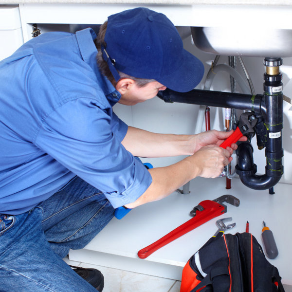 An image showing specialized plumbing equipment and a technician diagnosing a plumbing issue.