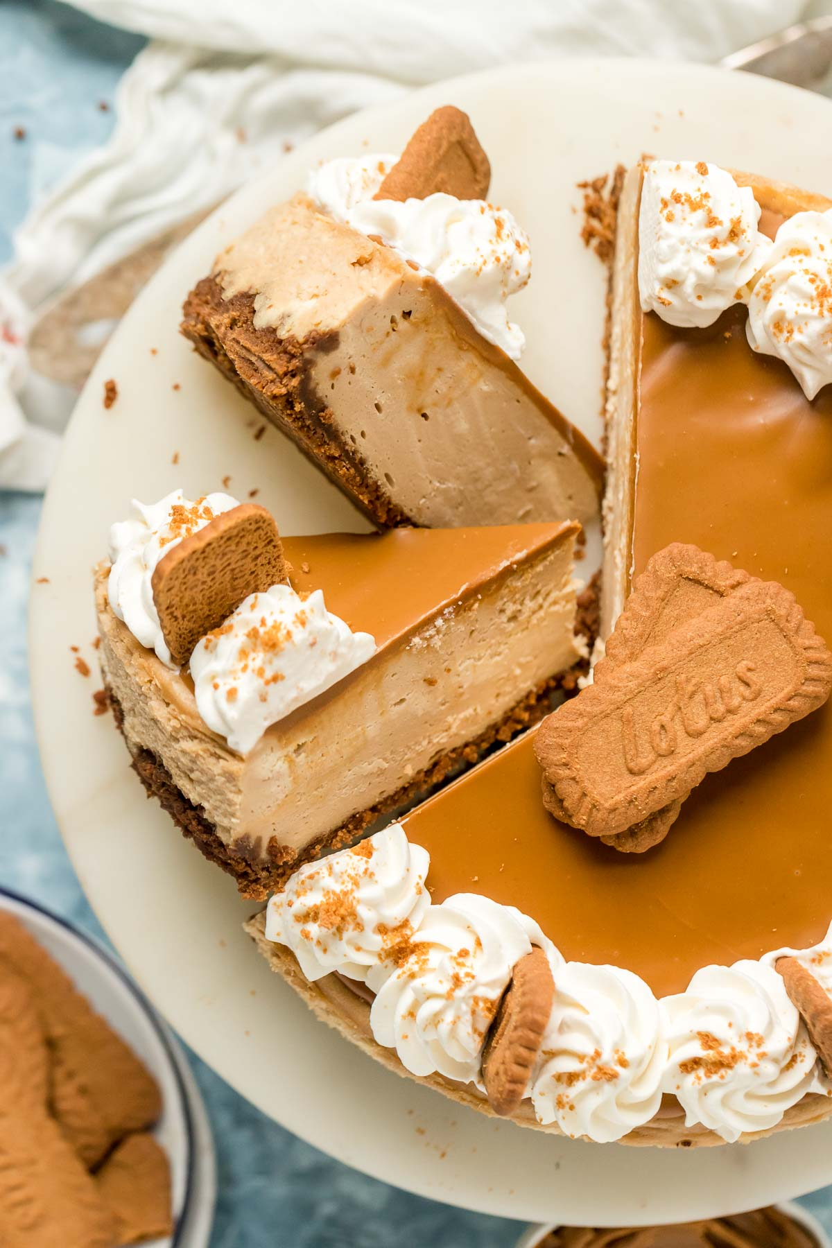 two cut slices of biscoff cheesecake on a cake stand