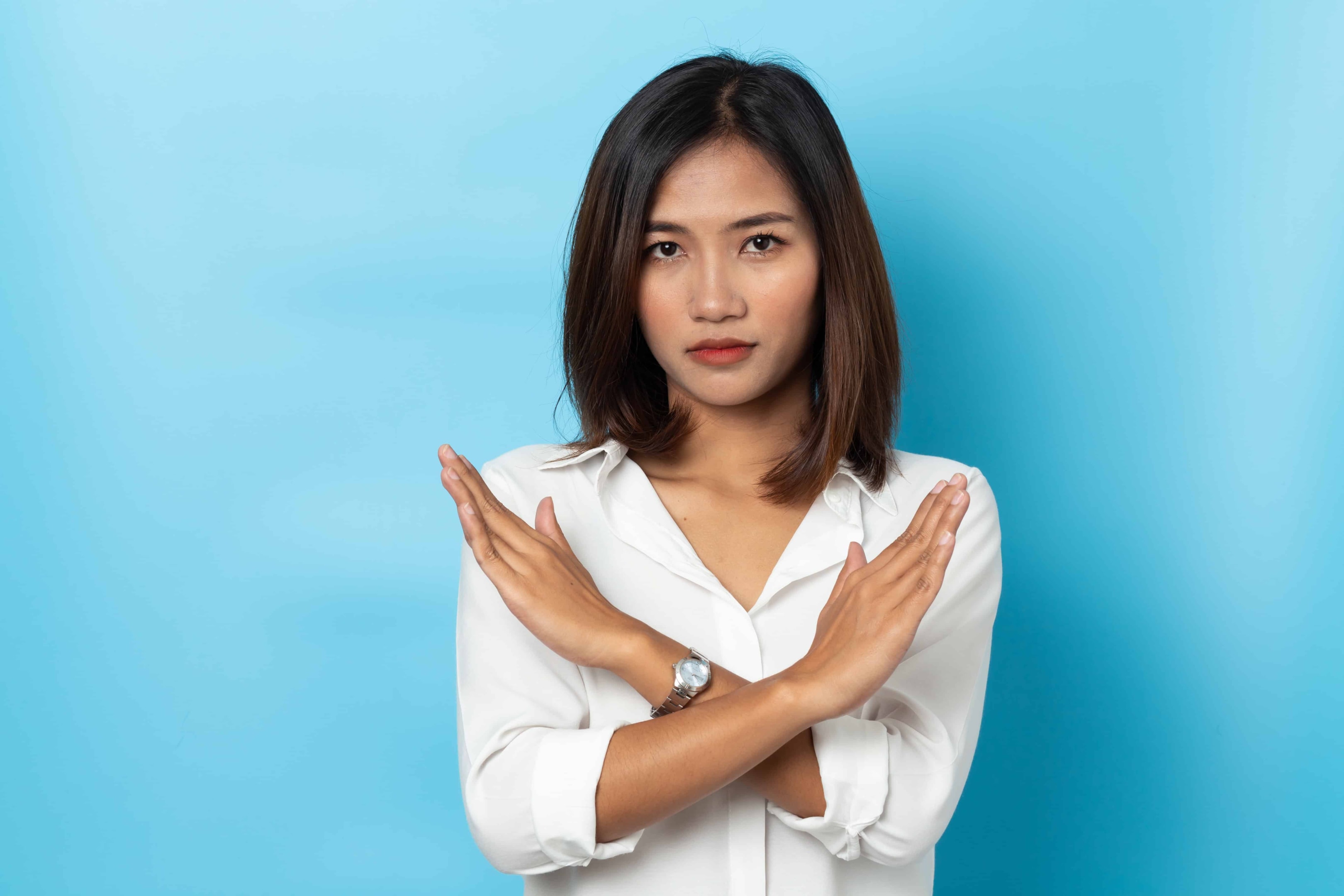 A couple holding their hands up making an x.