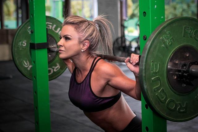 Woman performing a barbell back squat at a gym