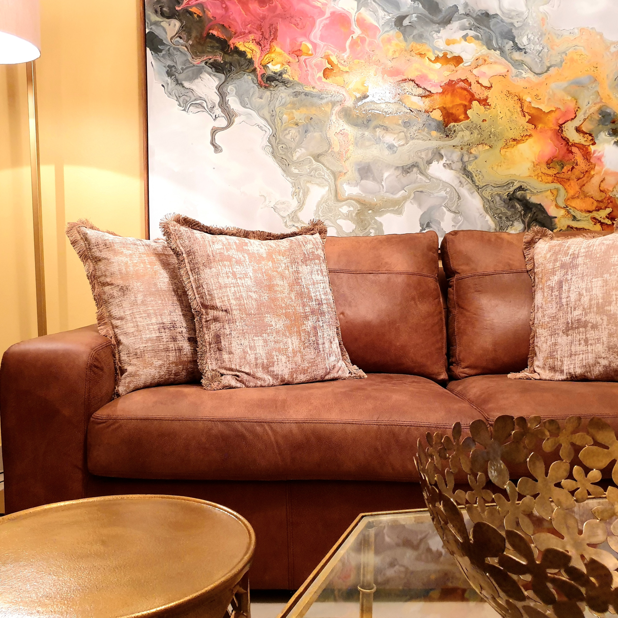 large abstract painting behind leather sofa