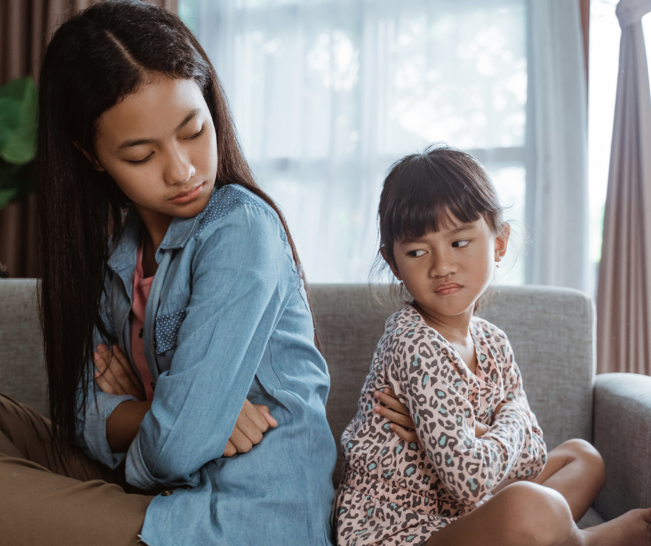 two kids sit back to back after an argument