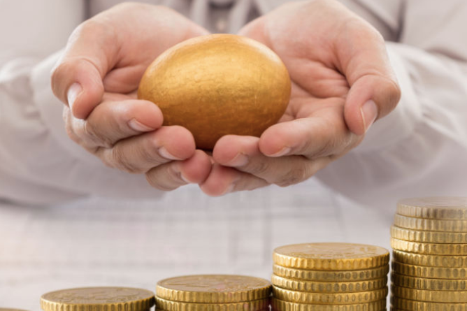 A person holding a golden egg with a stack of gold coins