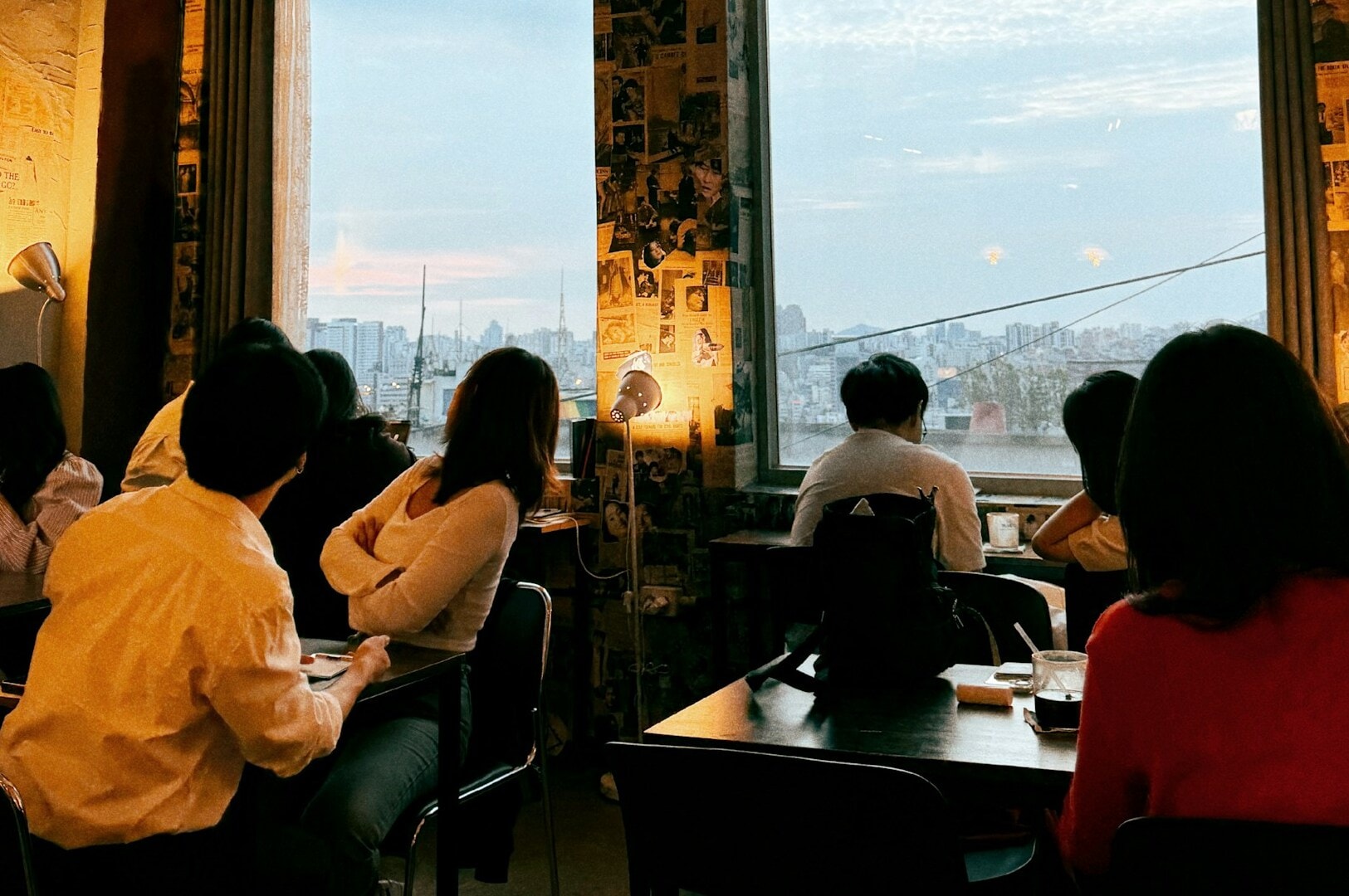 Guests enjoying meals at tables in a fine dining restaurant, featuring expansive windows that enhance the ambiance.