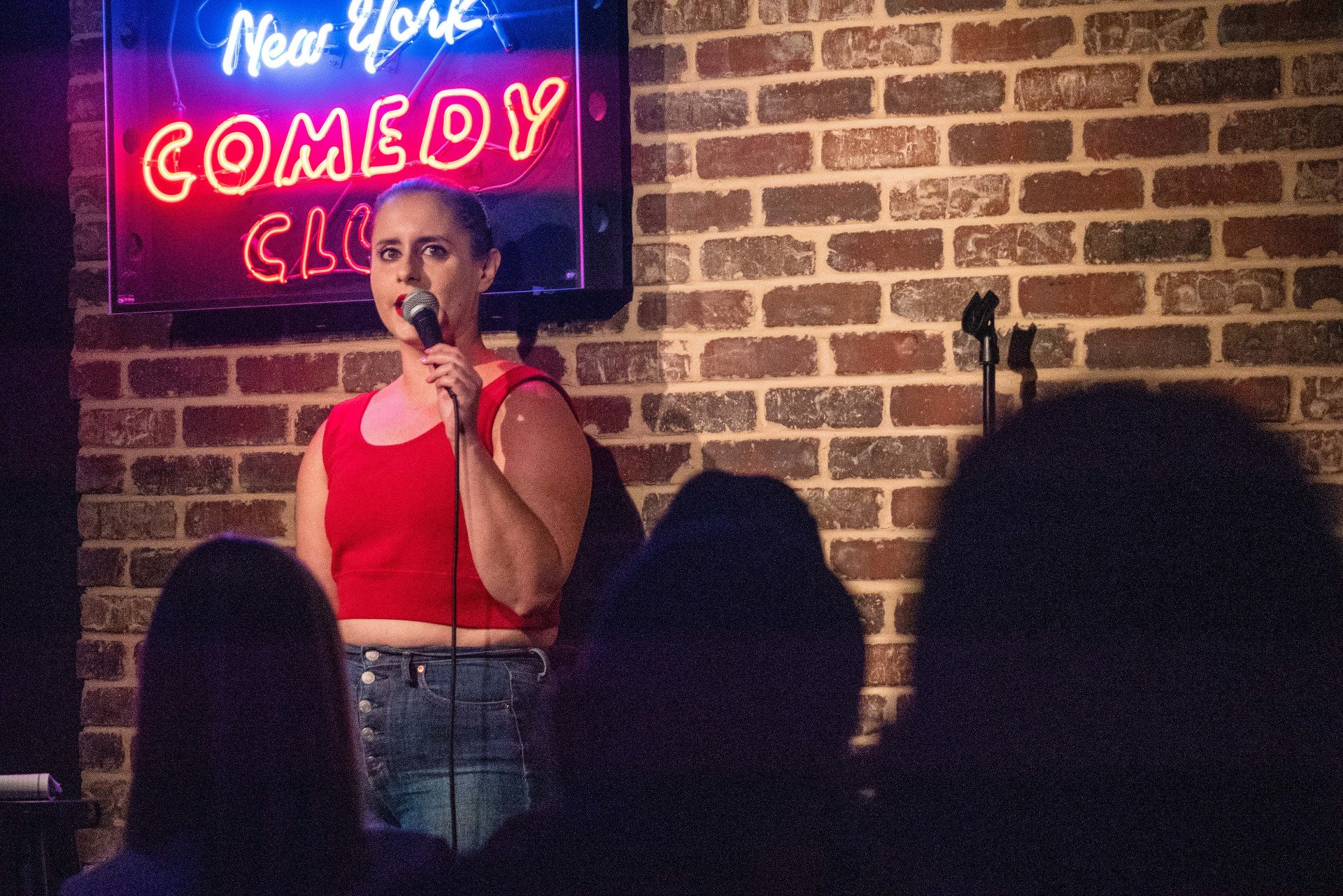 Source: https://newyorkcomedyclub.com/blog/new-york-comedy-club-celebrates-4th-anniversary   Caption: Comedian on stage at New York Comedy Club