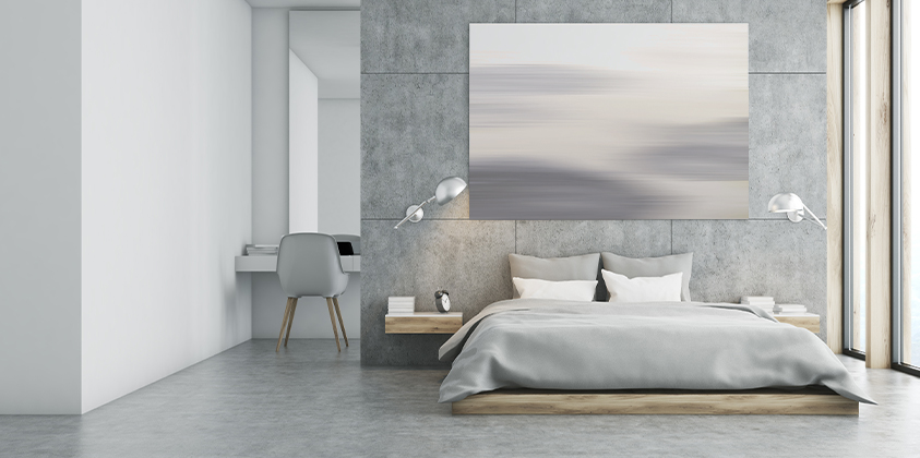 This grey and white bedroom benefits from tall, wide windows that let natural light in to brighten the space. Everything in the room fits a pale grey, white and wood colour scheme, down to the abstract painting above the bed. 