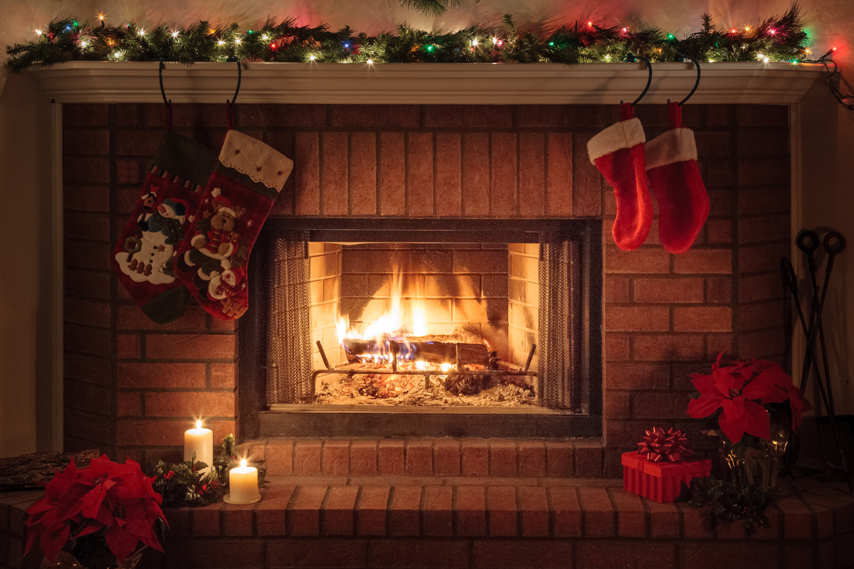 A beautifully decorated christmas mantel with classic christmas colors.