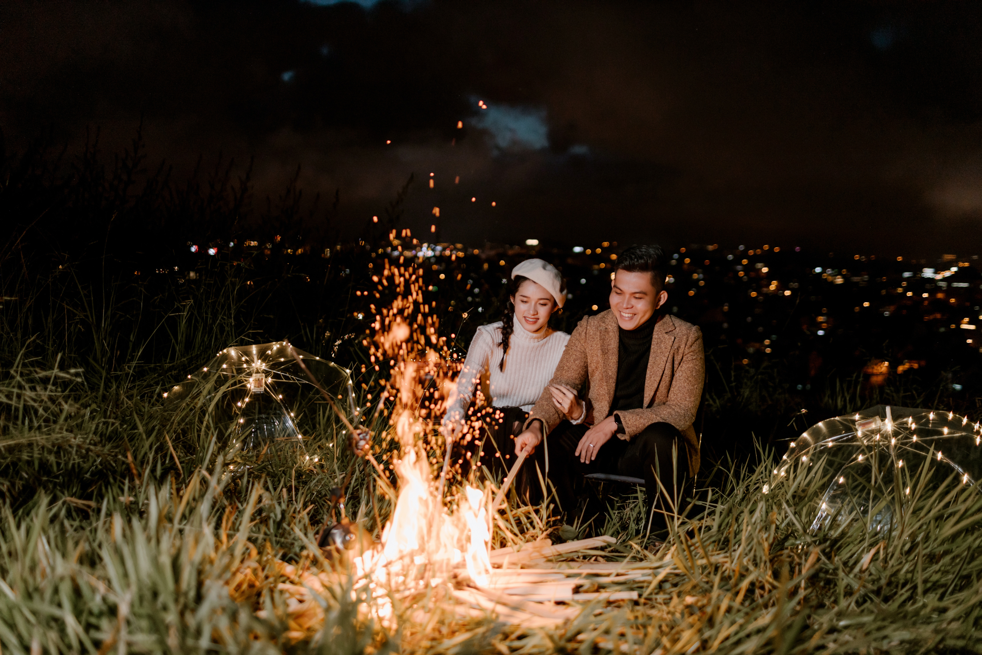couple sitting by a camp fire 