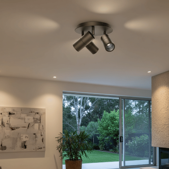 Adjustable ceiling-mounted track spotlight fixture with three matte black heads, a functional chandelier alternative for focused lighting.