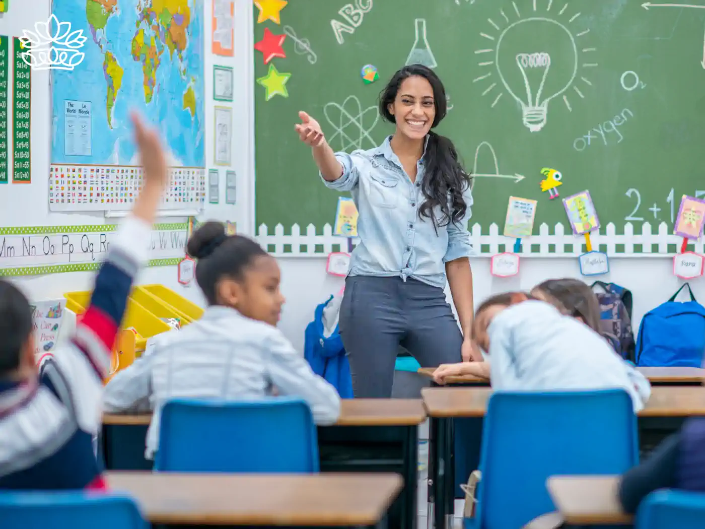 Joyful teacher engaging with enthusiastic primary school students in a vibrant classroom setting, showcasing the spirit of learning and education, delivered with heart by Fabulous Flowers and Gifts.