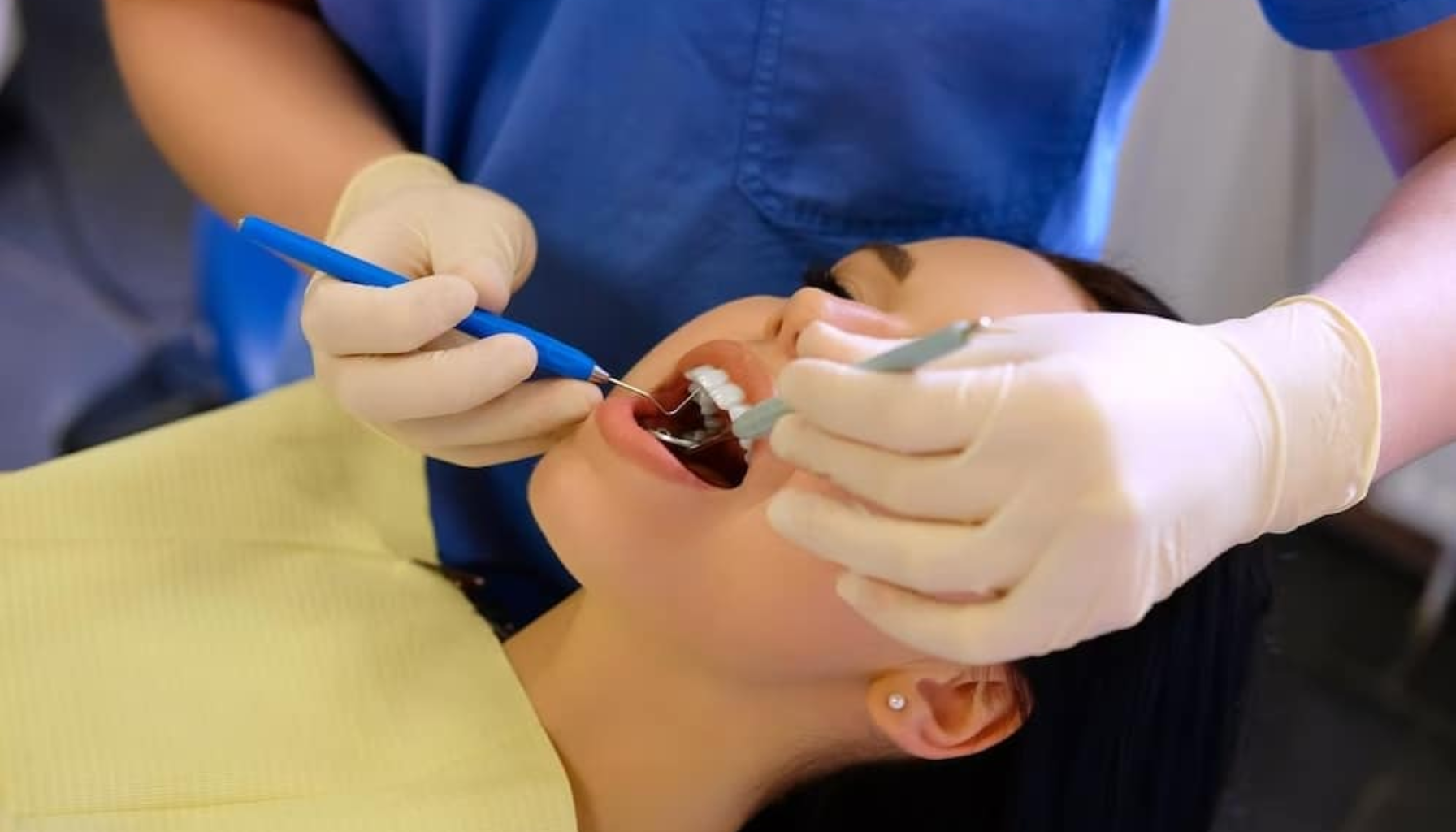 "Tannlege undersøker pasientens tenner med speil og instrumenter under rutinekontroll."