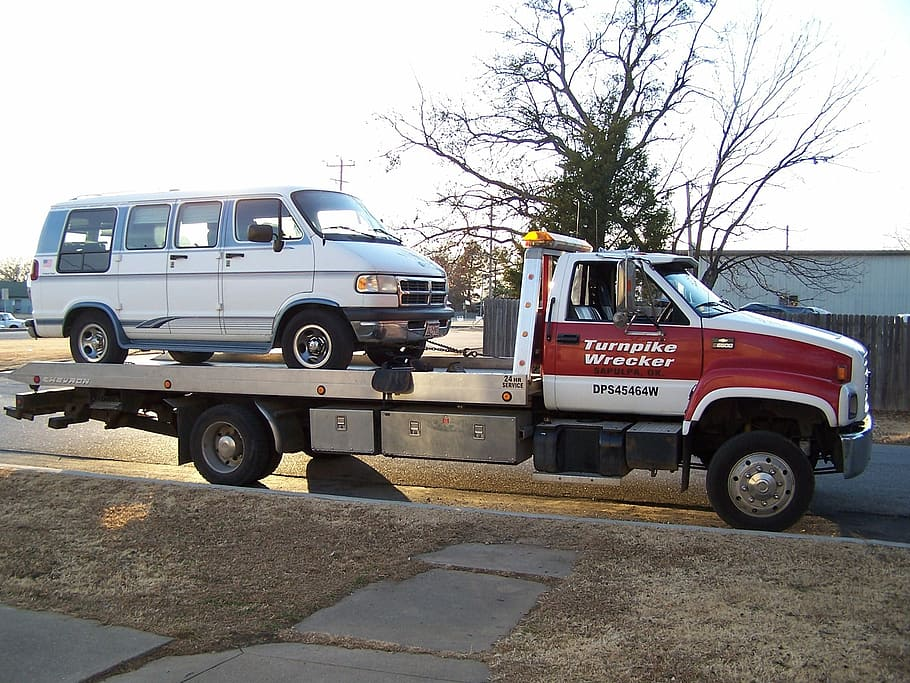 A junk car being towed away by a cash for cars company