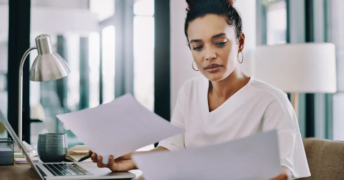 Woman reviewing a notice of federal tax lien and IRS tax documents at her home office.