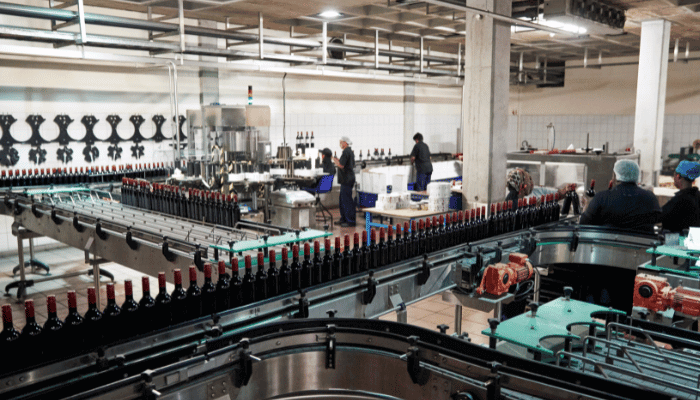 View of wine bottling facility with technicians working; example of a manufacturing facility.