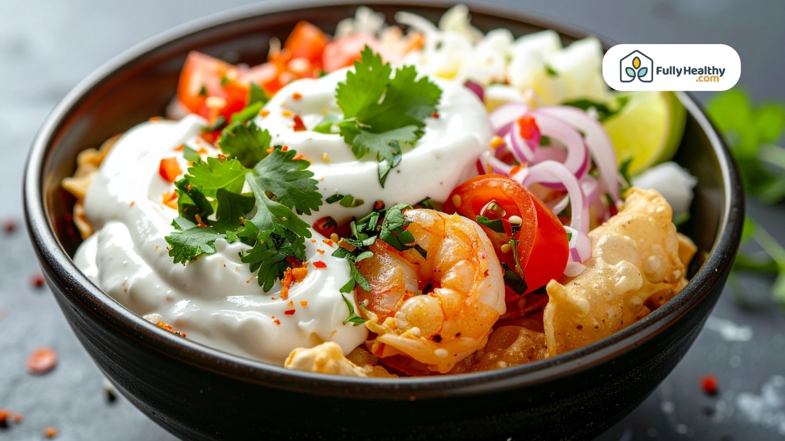 Shrimp salad bowl topped with yogurt cilantro tomatoes and onions