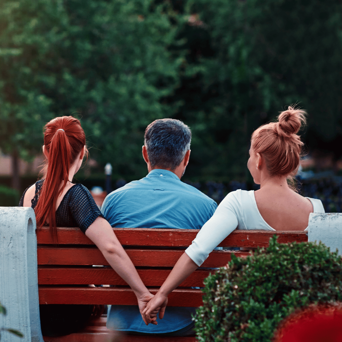 Infidelity, woman holding hands behind mans back -  Featured In: How To Stop Overthinking After Being Cheated On