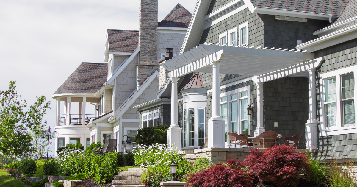 Row of upscale North Wildwood vacation homes with porches, balconies, and landscaped gardens.