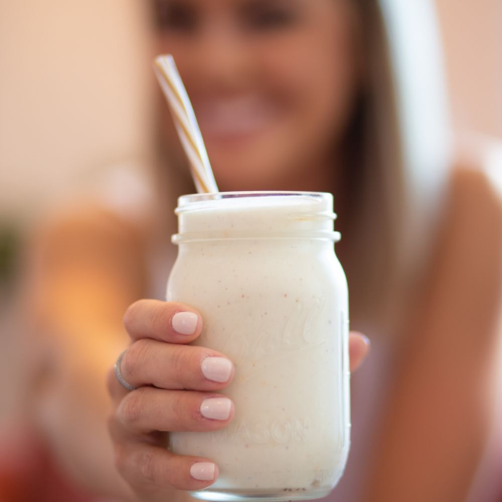 A person drinking a protein shake and smiling