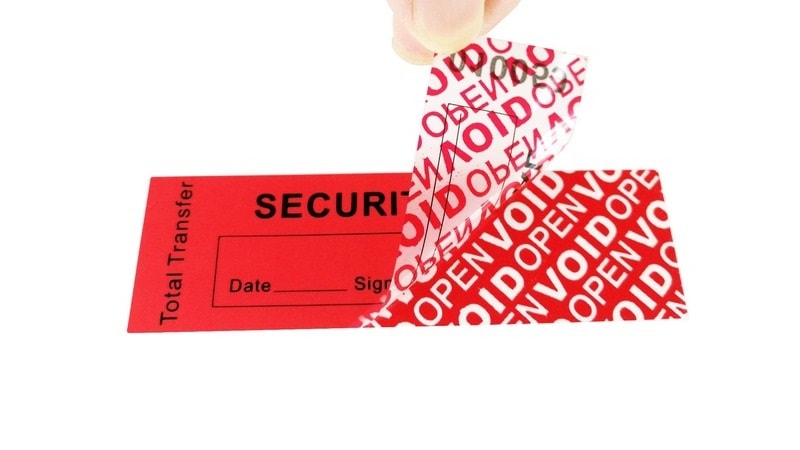 Red tamper-evident security label being peeled off