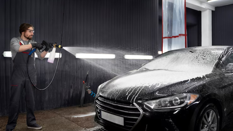 A professional using high pressure water to wash the car with PPF coating