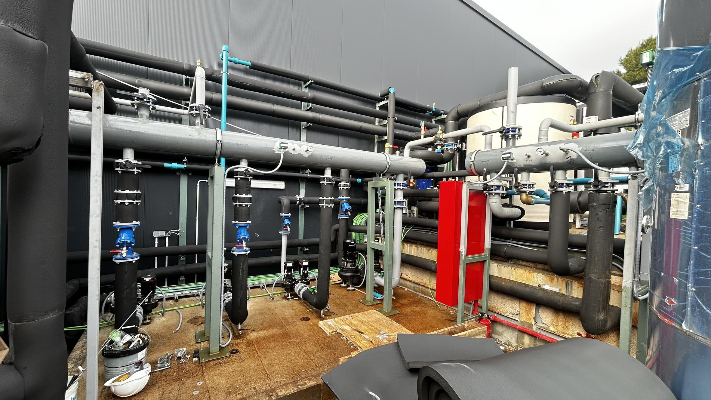 Een moderne koelinstallatie met leidingen en technische apparatuur voor een ijsbaan, ideaal voor schaatsen en evenementen in de stad Antwerpen. Deze installatie zorgt ervoor dat de ijsoppervlakte perfect blijft voor zowel beginners als ervaren schaatsers.