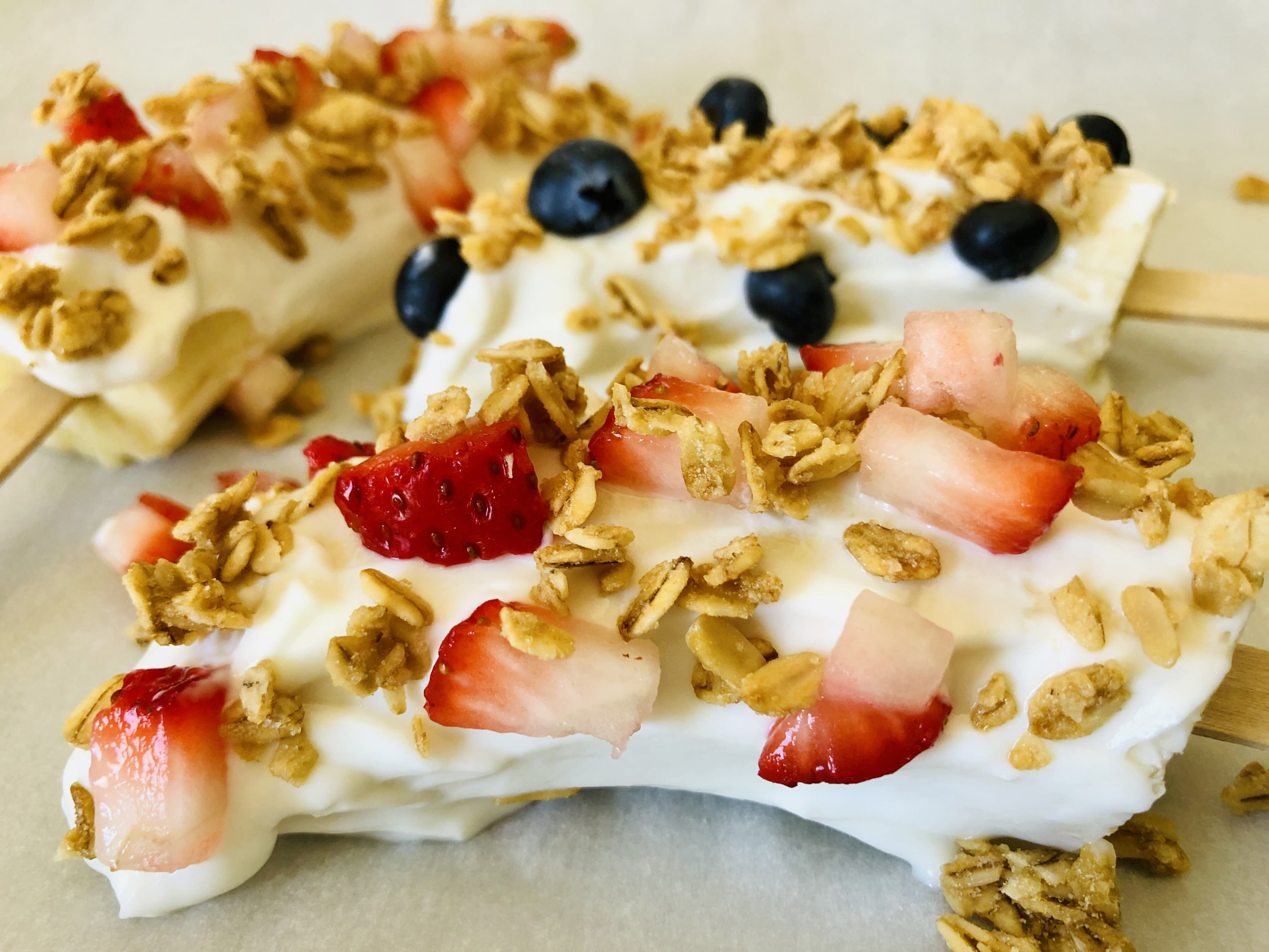yogurt covered bananas with strawberry and granola