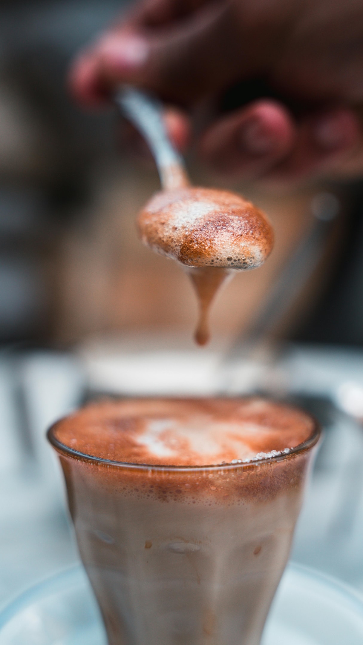 Coffee foam in a glass and spoon