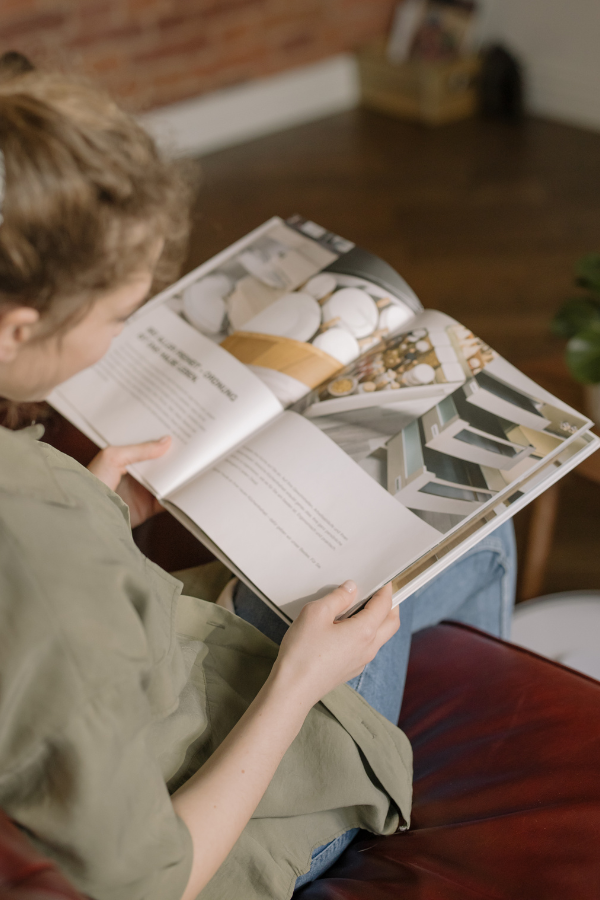 a young woman looks through a building magazine